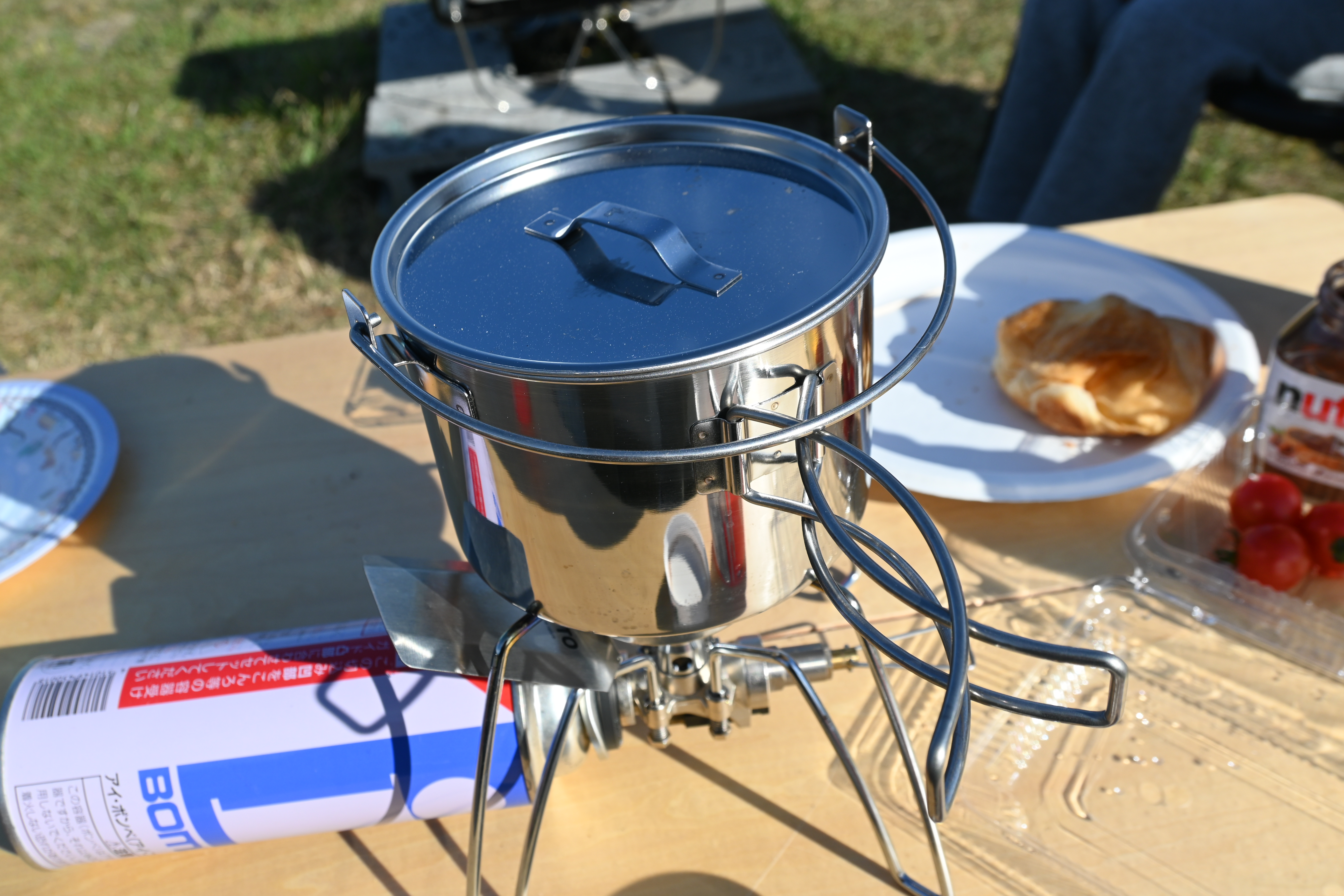 スノーピーク ケトル No.1 を SOTO のアウトドアバーナーに乗せ、家族キャンプの朝食卓で湯を沸かしている写真