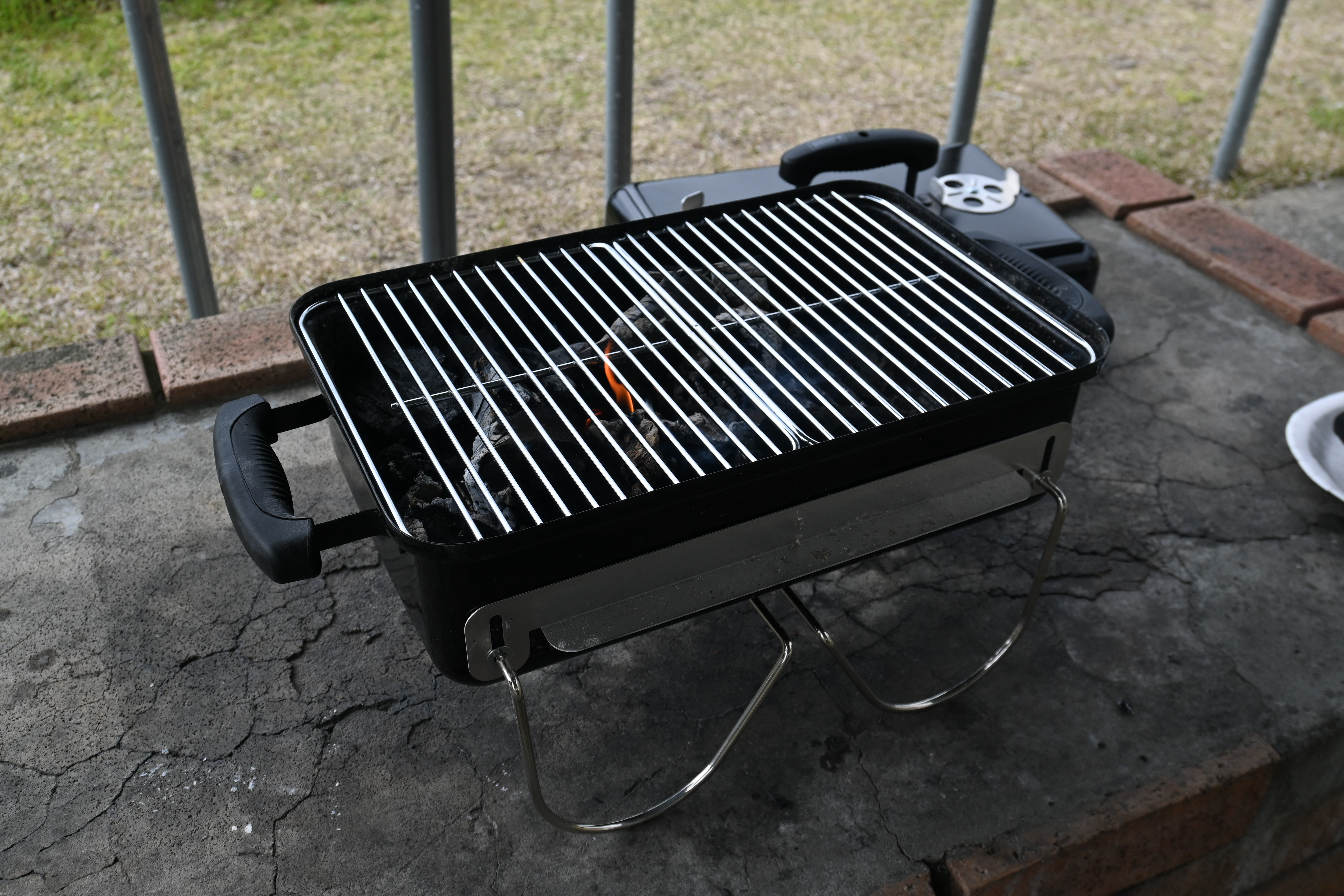 Weber Go-Anywhere を開いて炭を仕込み、市営バーベキュー場の卓上に据えた写真